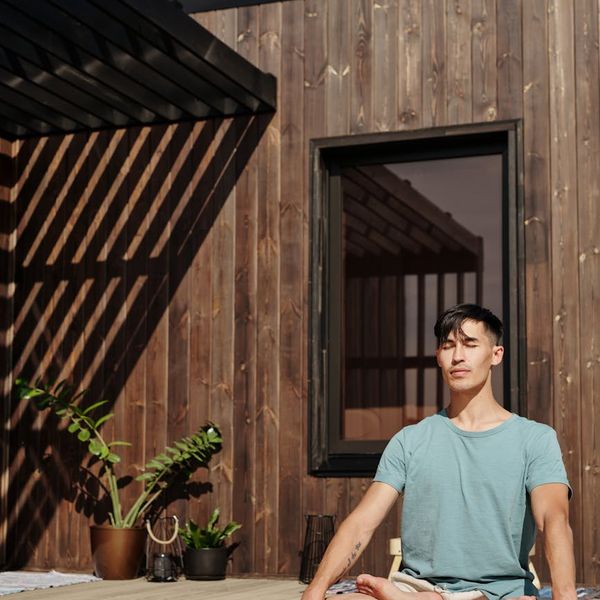 Man meditating peacefully outdoors with a serene natural background.